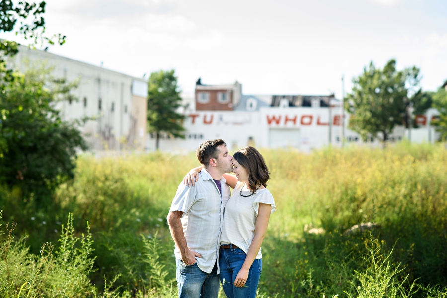 A couple kiss while standing in an abandoned lot in Fishtown for their engagement session.